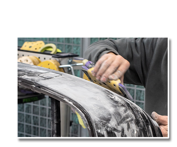 A mechanic performs a precise accident repair on a damaged vehicle.
